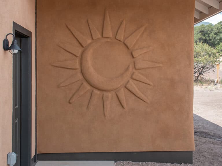 Sun and Moon plaster design on an exterior straw bale wall