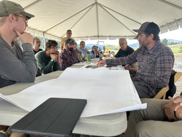 Group looking at plans during a straw bale construction workshop