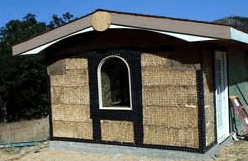 Sunset Cottage straw bale house with strawbale walls, felt, window and roof rough
