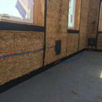 straw bale wall with roofing felt, outlet, electrical, window, wire mesh