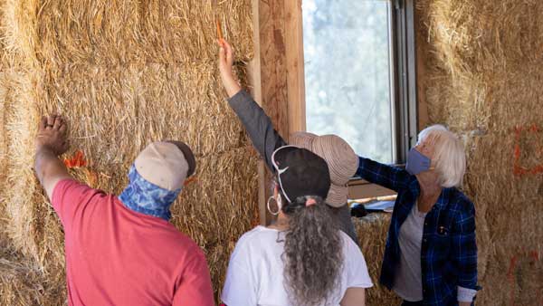 Straw bale building, 3-Day On-Site Training to learn strawbale construction techniques, such as how to layout the bale wall of this kitchen for utilities.